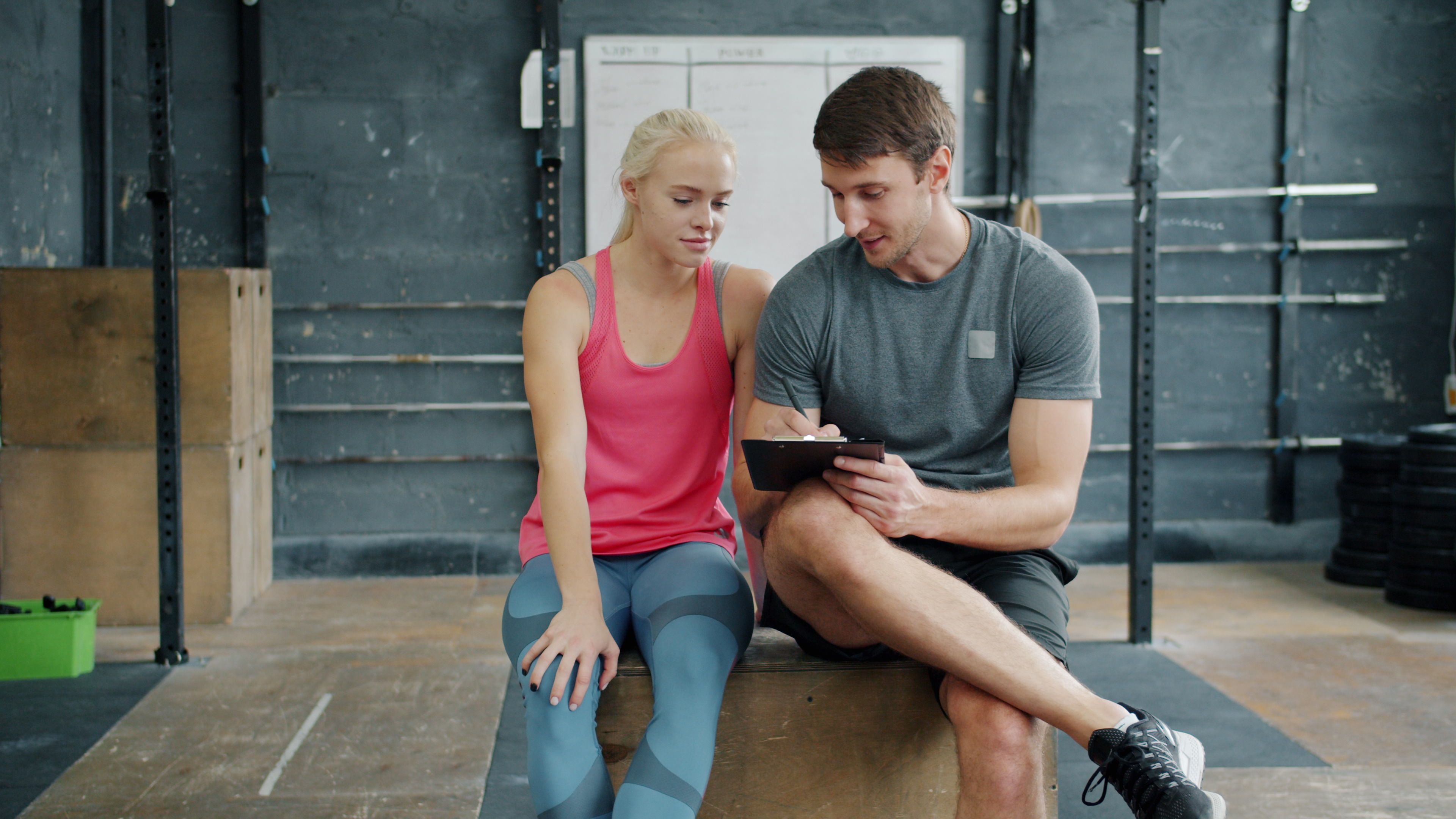 Personal trainer discussing a workout plan with a client in a gym