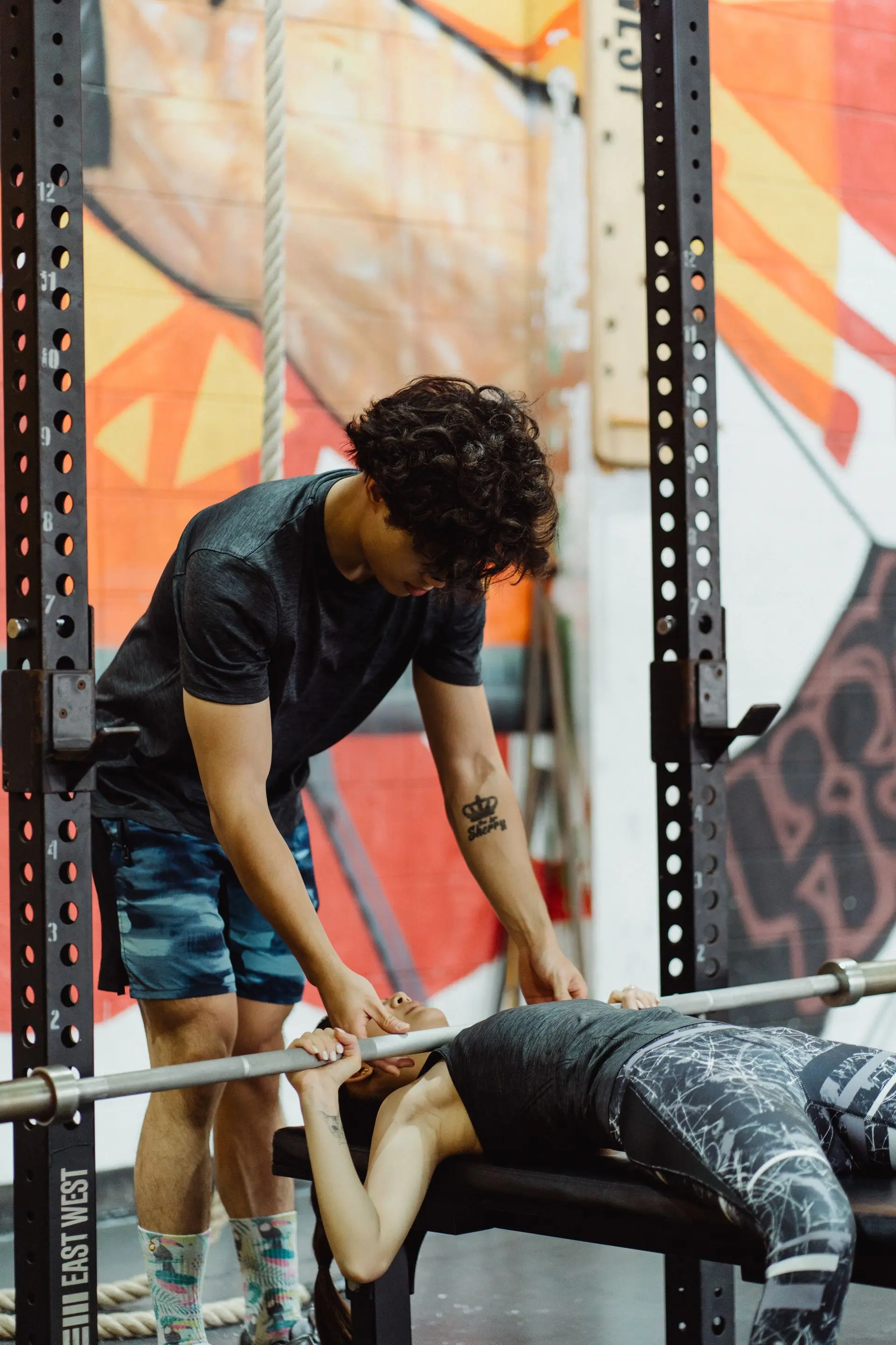 Personal trainer assisting a client during a bench press strength training session